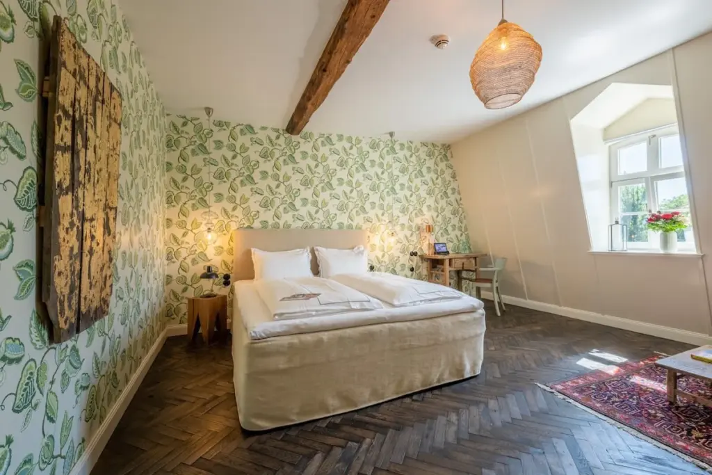 Schlafzimmer mit gemusterter Wand und Doppelbett