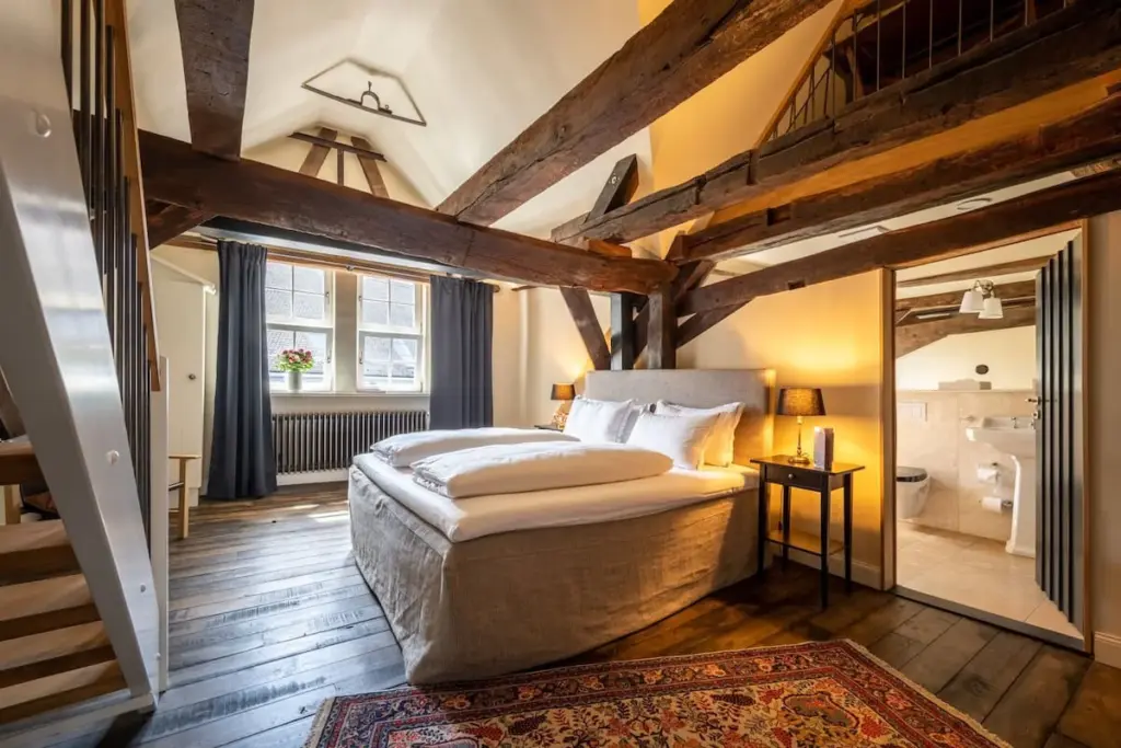 Dachzimmer mit sichtbaren Holzbalken und Sofa