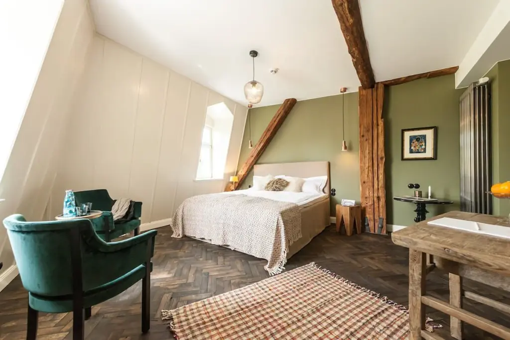 Dachgeschosszimmer mit Holzbalken und Bett