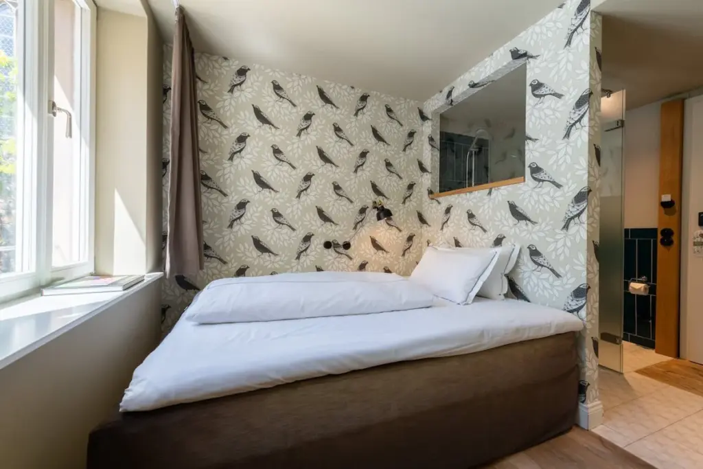 Schlafzimmer mit gemusterter Tapete und Doppelbett