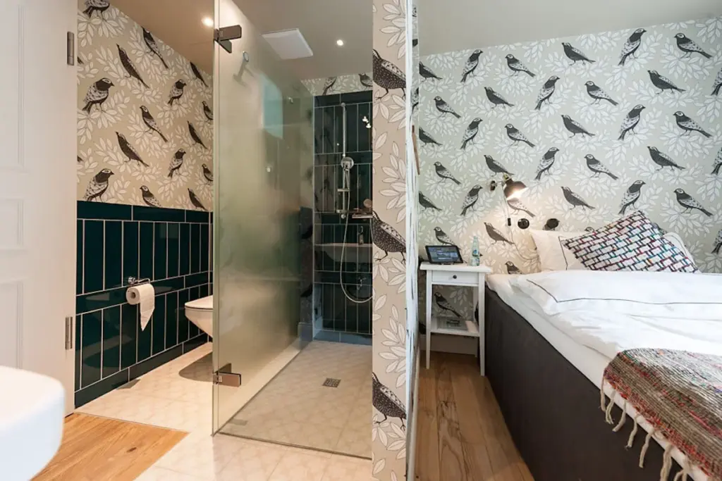 Badezimmer mit Dusche und gemusterter Wand
