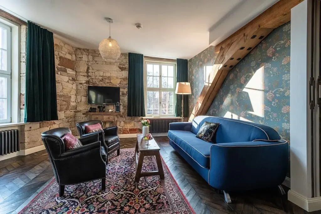 Hotelzimmer mit Sofa, Tisch und rustikalem Design