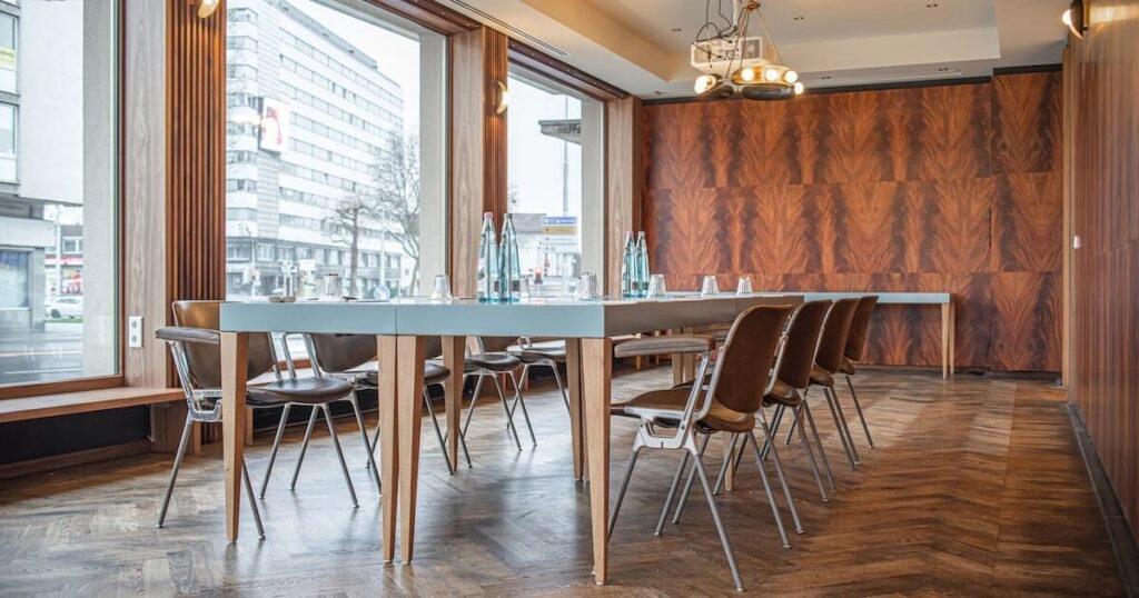 Konferenzraum mit Tischen und Stühlen am Fenster