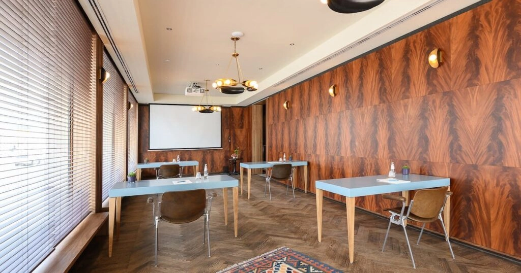 Tagungsraum mit Leinwand und Holzverkleidung